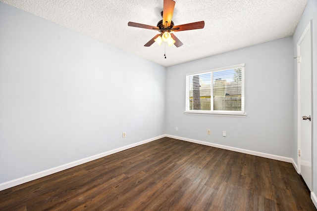 spare room with dark wood finished floors, a textured ceiling, a ceiling fan, and baseboards