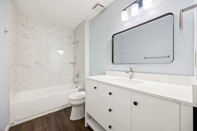 bathroom with visible vents, toilet, a textured ceiling, wood finished floors, and shower / bathtub combination