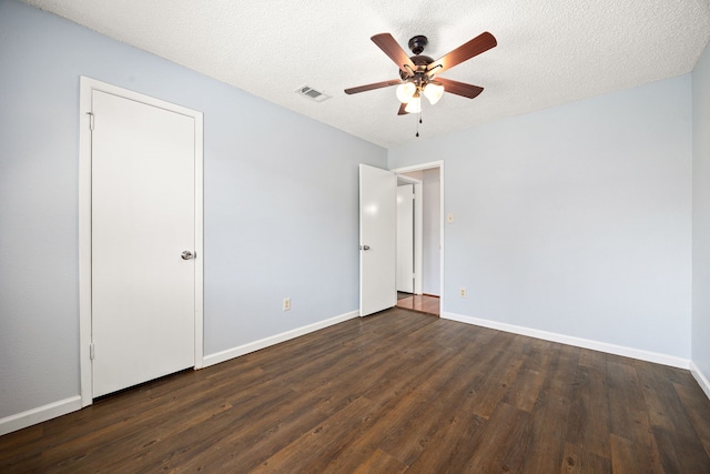 unfurnished bedroom featuring dark wood-type flooring, baseboards, visible vents, and a textured ceiling