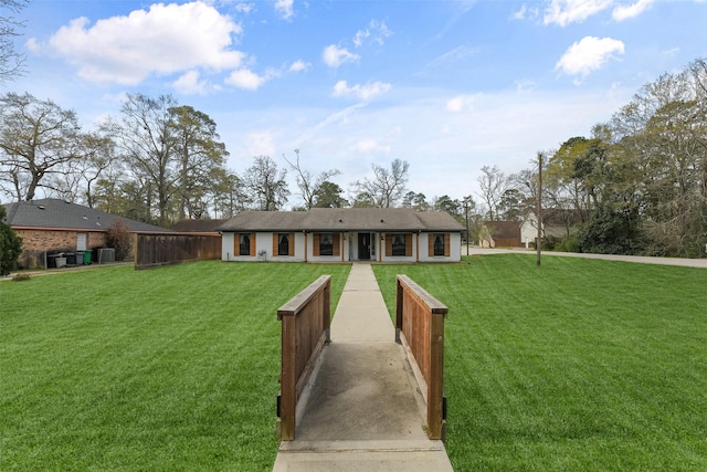 view of front of house with a front lawn and central air condition unit