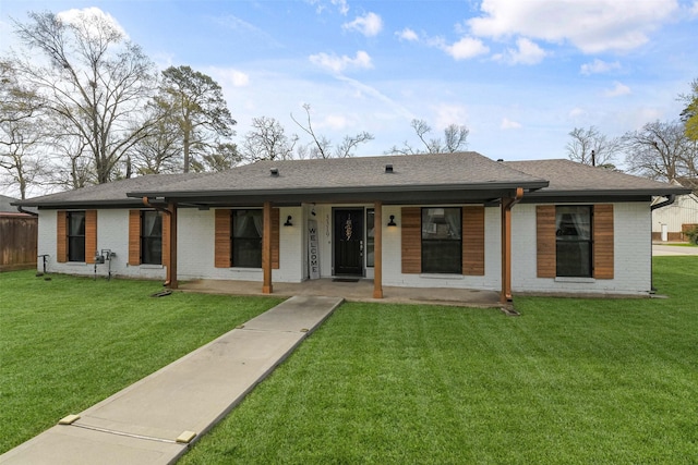 view of front of house featuring a front lawn, covered porch, brick siding, and a shingled roof