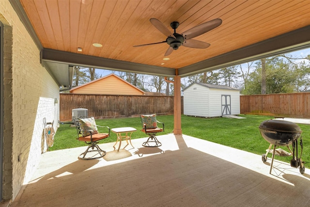 view of patio featuring a storage unit, area for grilling, a fenced backyard, an outdoor structure, and ceiling fan