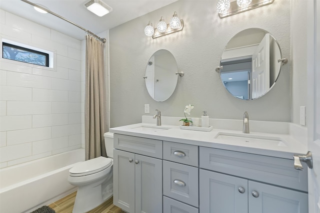 full bath featuring toilet, wood finished floors, shower / tub combo with curtain, and a sink