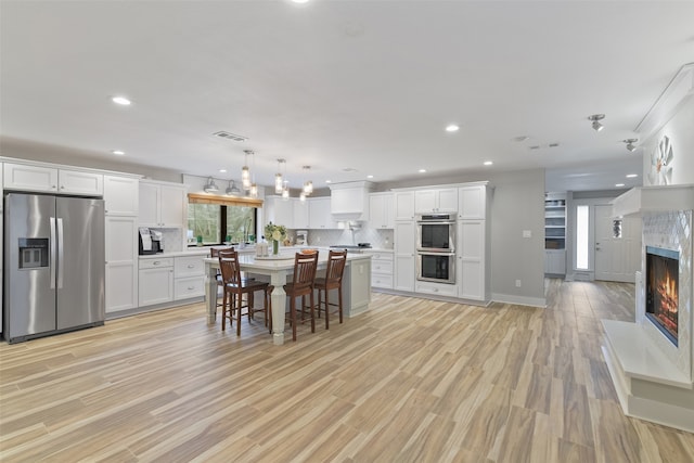 kitchen featuring visible vents, backsplash, light countertops, appliances with stainless steel finishes, and white cabinets