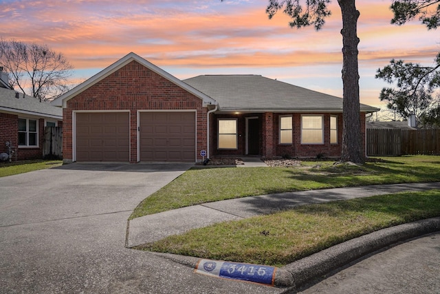 single story home with a front yard, fence, concrete driveway, a garage, and brick siding