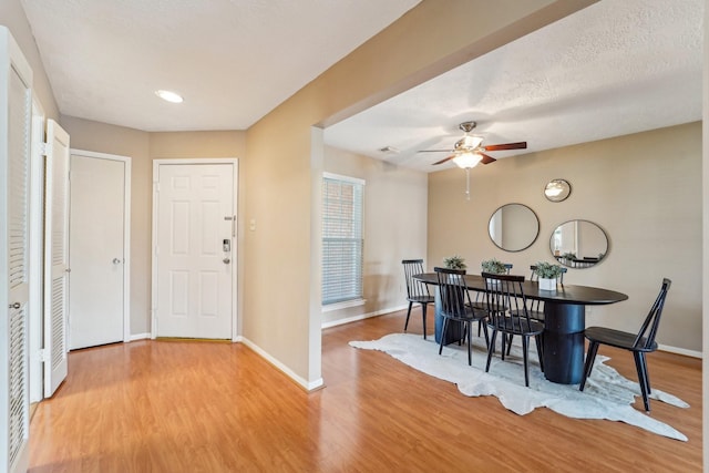 dining room with ceiling fan, baseboards, a textured ceiling, and wood finished floors