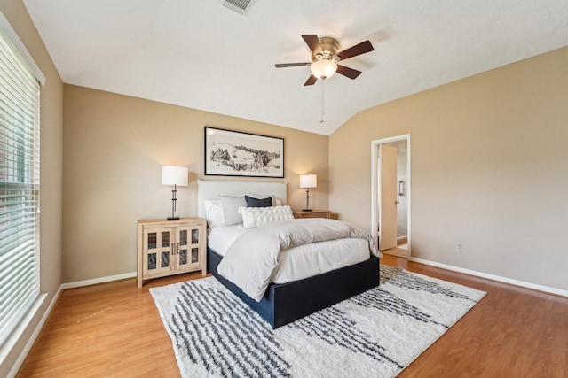 bedroom featuring vaulted ceiling, wood finished floors, baseboards, and ceiling fan