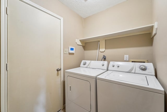 laundry room with washer and dryer, laundry area, and a textured ceiling