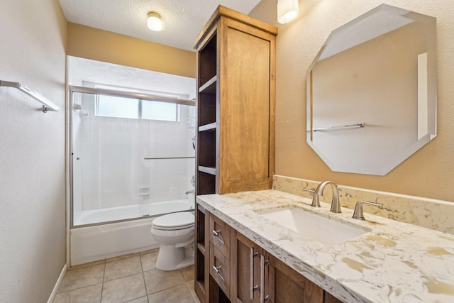 full bath featuring tile patterned flooring, toilet, vanity, shower / bath combination with glass door, and a textured ceiling