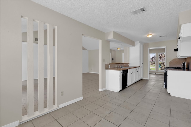 kitchen featuring visible vents, black dishwasher, white cabinets, light tile patterned flooring, and gas range