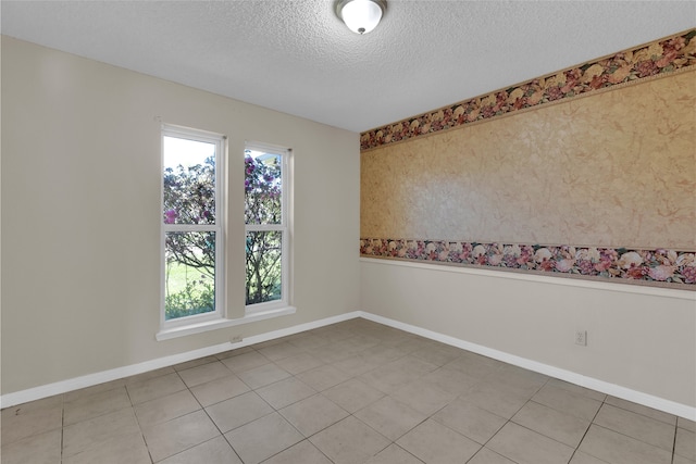 empty room featuring baseboards and a textured ceiling