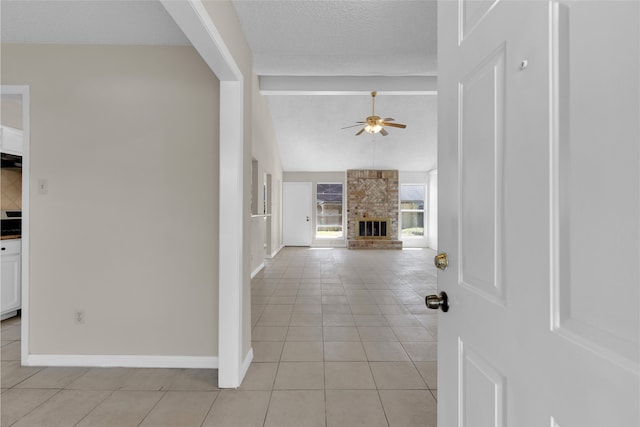 interior space with light tile patterned floors, vaulted ceiling with beams, a textured ceiling, and baseboards