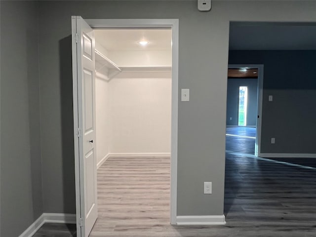 hallway featuring wood finished floors and baseboards