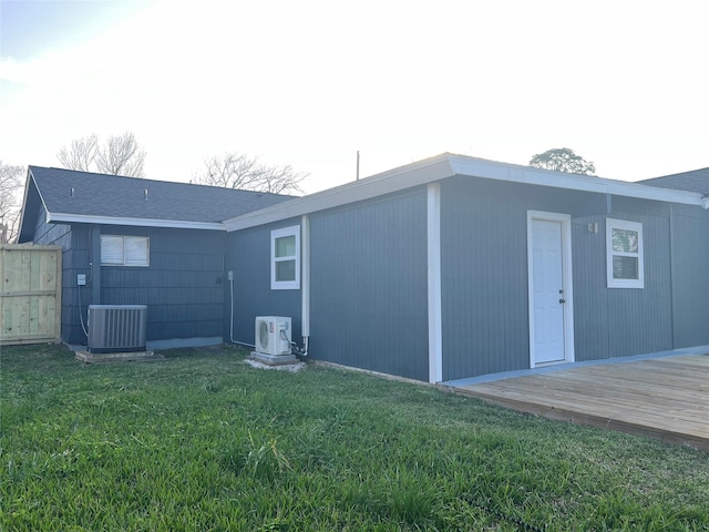 rear view of house with ac unit, a yard, central AC unit, and a deck