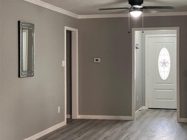 foyer with baseboards, light wood-style floors, ornamental molding, and a ceiling fan