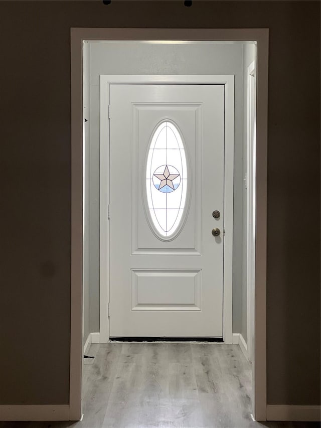 doorway to outside with baseboards and light wood finished floors