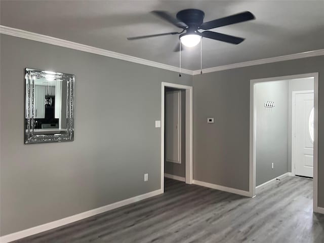 empty room featuring baseboards, a ceiling fan, wood finished floors, and crown molding