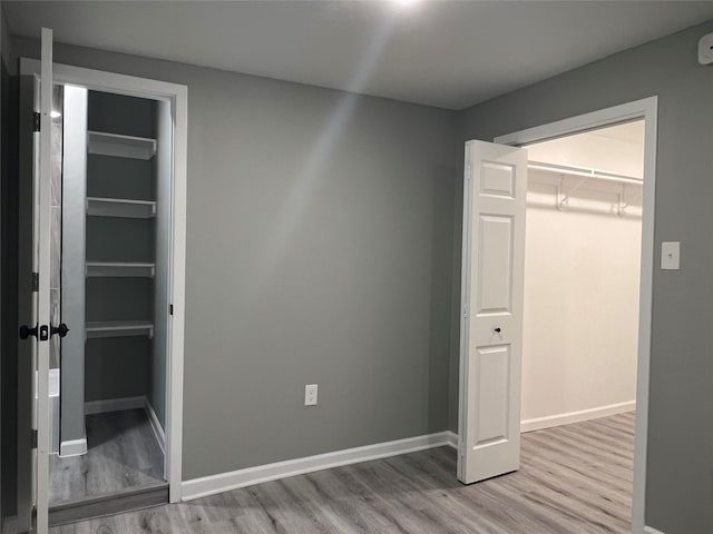 unfurnished bedroom with baseboards and wood finished floors