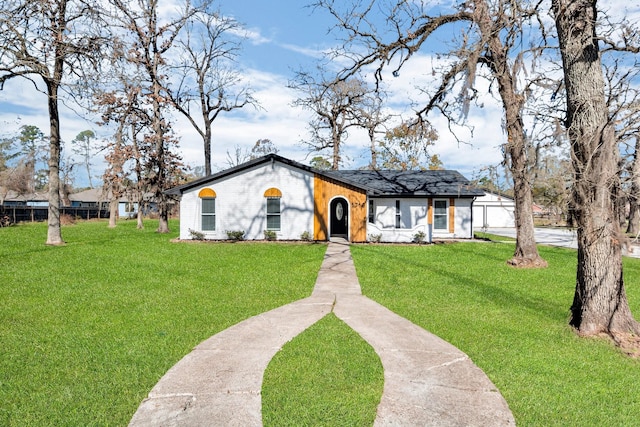 mid-century home featuring a front yard and fence