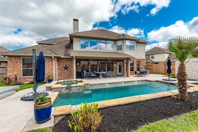 rear view of house featuring a patio, a fenced backyard, a pool with connected hot tub, a chimney, and brick siding