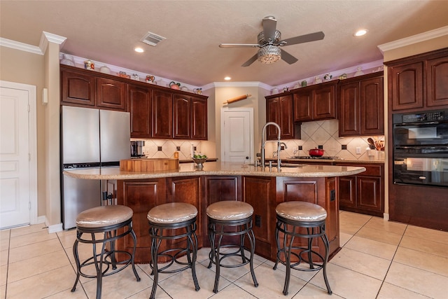 kitchen with light tile patterned floors, appliances with stainless steel finishes, a ceiling fan, and a sink