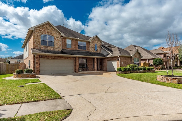 traditional-style home featuring a front lawn, fence, concrete driveway, a garage, and brick siding