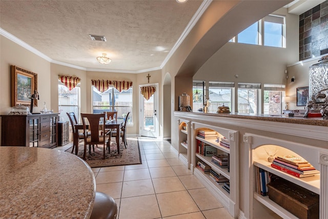 dining space featuring arched walkways, visible vents, light tile patterned floors, and ornamental molding