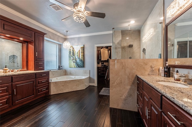 full bathroom with visible vents, a tile shower, wood finished floors, a ceiling fan, and a sink