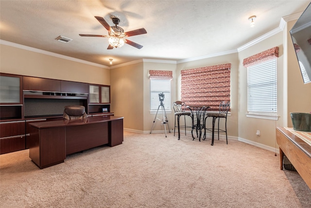 office featuring visible vents, crown molding, baseboards, light colored carpet, and ceiling fan