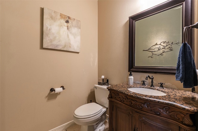 bathroom featuring vanity, toilet, baseboards, and tile patterned flooring