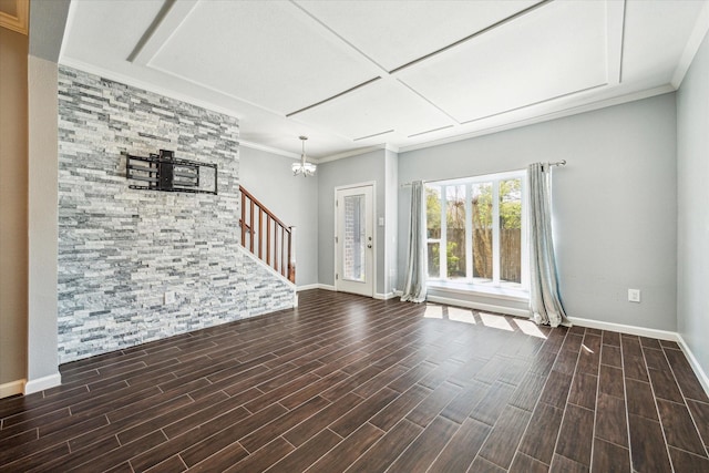 unfurnished living room with stairs, an inviting chandelier, baseboards, and wood finish floors