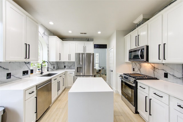 kitchen with a wealth of natural light, visible vents, a kitchen island, and appliances with stainless steel finishes