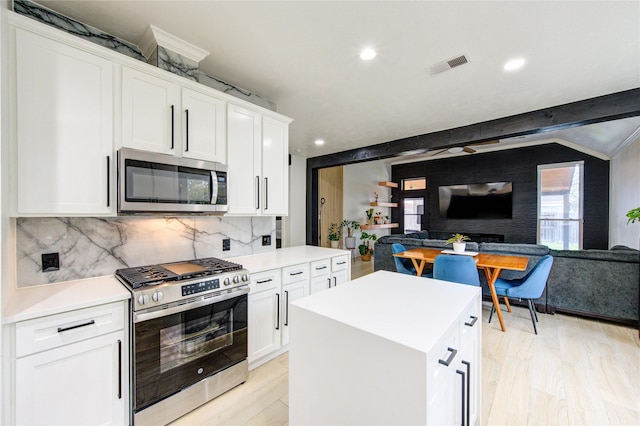 kitchen with visible vents, backsplash, open floor plan, stainless steel appliances, and light countertops