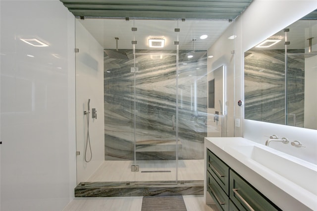 full bath with a marble finish shower and vanity