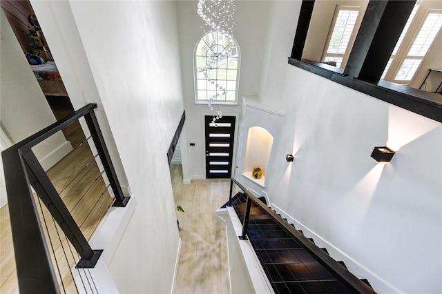 stairs with a high ceiling, baseboards, and wood finished floors