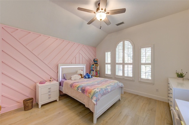 bedroom featuring baseboards, visible vents, light wood finished floors, lofted ceiling, and ceiling fan