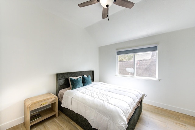 bedroom featuring light wood-style flooring, lofted ceiling, baseboards, and ceiling fan