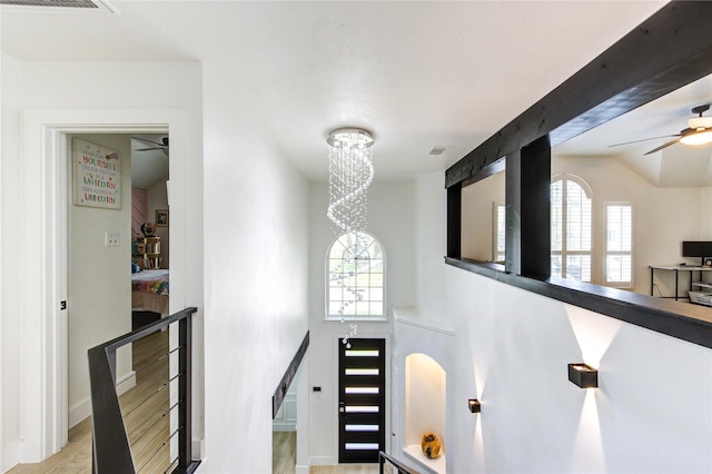 stairs featuring visible vents, wood finished floors, and ceiling fan