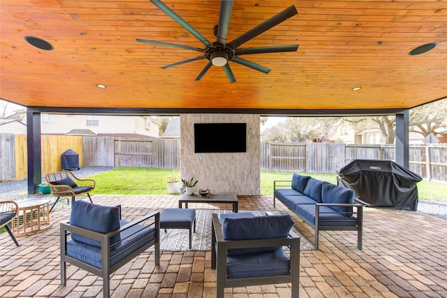 view of patio with ceiling fan, area for grilling, a fenced backyard, and an outdoor hangout area