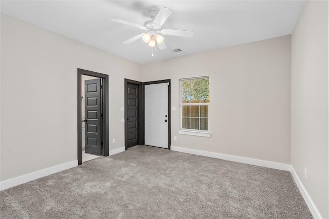 unfurnished bedroom featuring visible vents, carpet flooring, baseboards, and ceiling fan