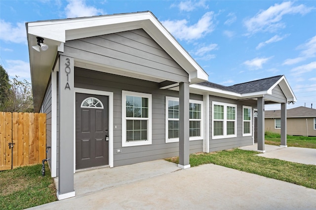 view of front of house with a patio and fence