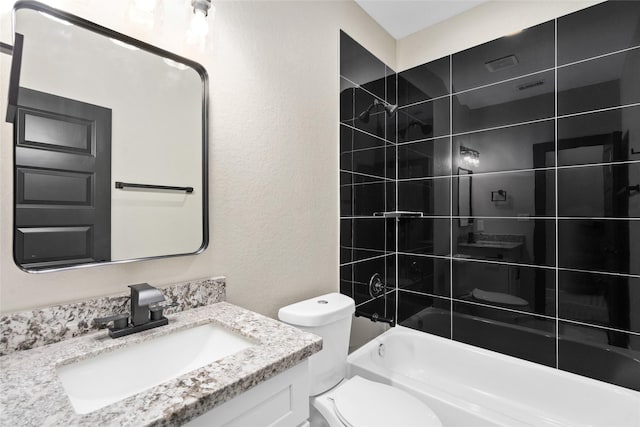 bathroom with vanity, shower / tub combination, toilet, and a textured wall