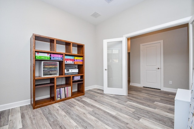 interior space featuring french doors, baseboards, and wood finished floors