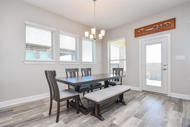 dining space with a notable chandelier, light wood-style flooring, and baseboards