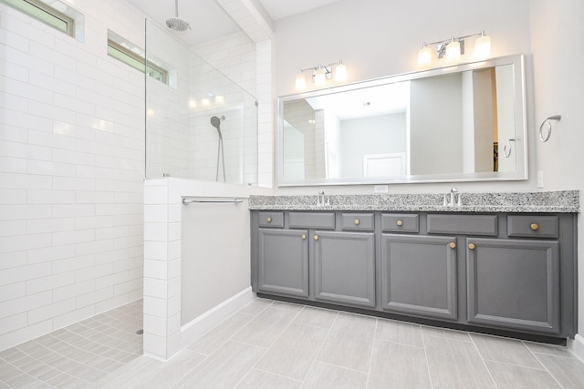 full bath with double vanity, a walk in shower, and a sink