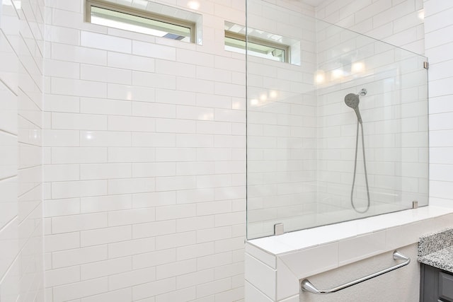 bathroom featuring walk in shower and vanity