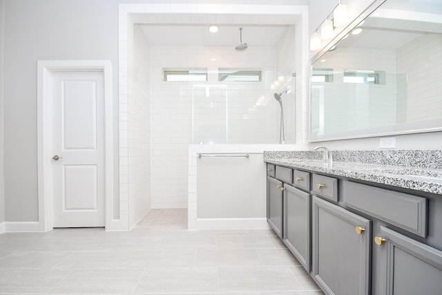 bathroom featuring double vanity, a walk in shower, and a sink