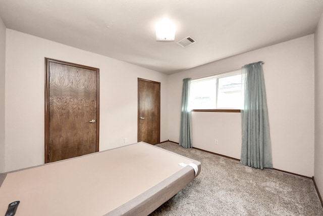 carpeted bedroom featuring visible vents and multiple closets