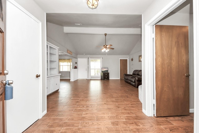 entrance foyer featuring baseboards, light wood-style flooring, vaulted ceiling with beams, and a ceiling fan