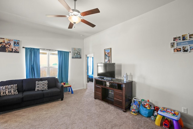 carpeted living area with a ceiling fan and baseboards